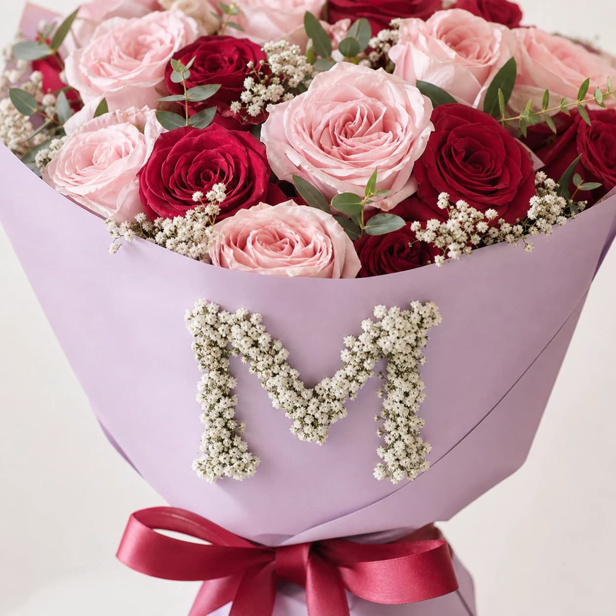 White flowers forming the letter M on lilac bouquet wrapping