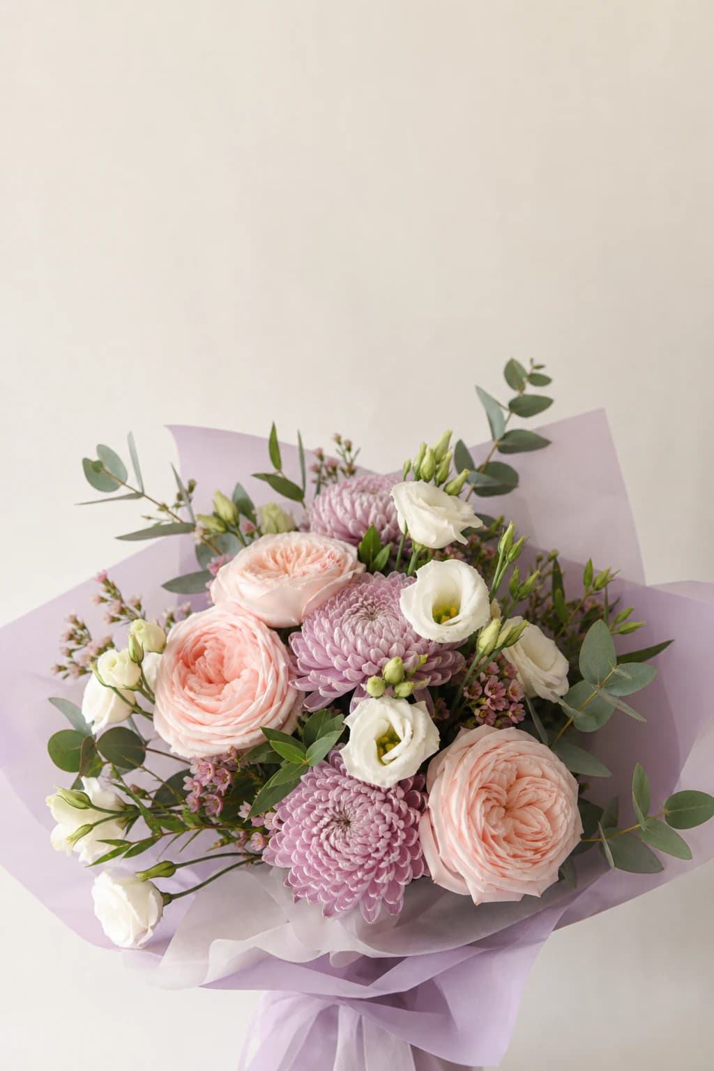 Pastel mixed-flower bouquet in lilac wrapping