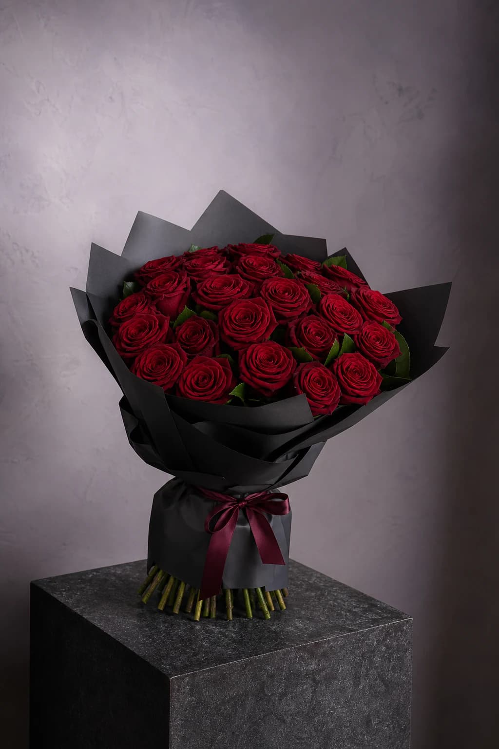 Deep crimson rose bouquet in architectural black wrapping